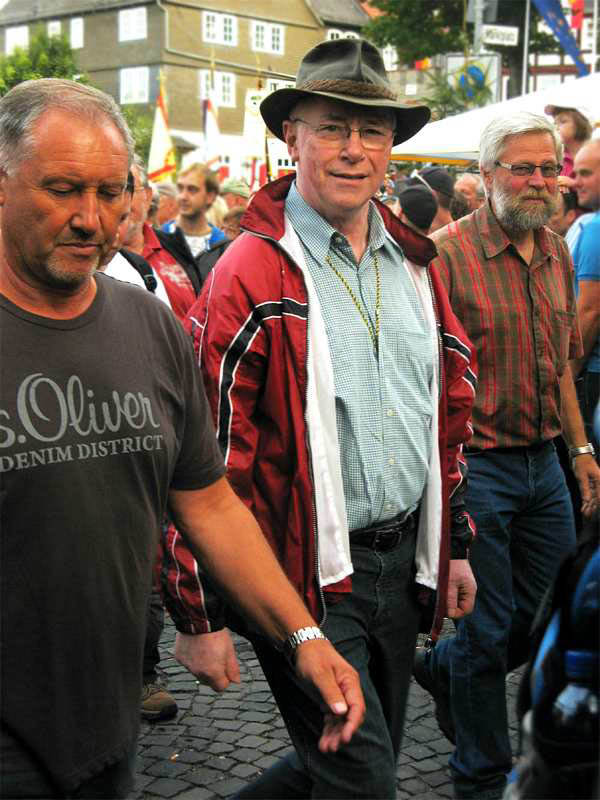 3 citizens march out of Biedenkopf's village square to begin the Grenzgang border check.